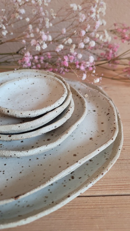 Assiettes empilées, émail blanc satiné moucheté