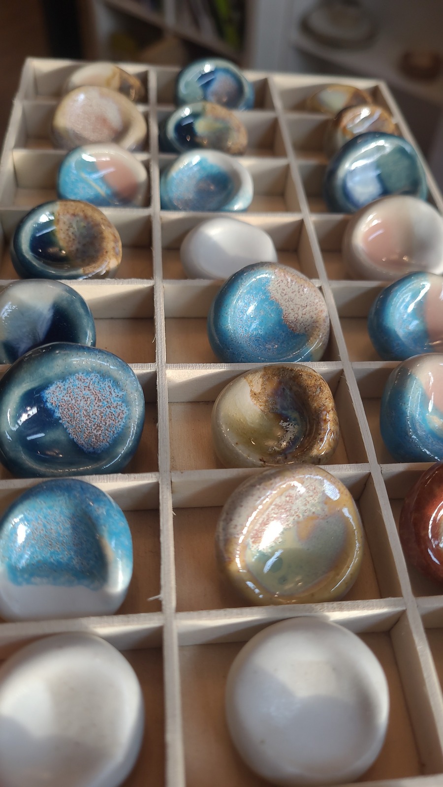 Worry stones émaillées bleues et roses dans des casiers