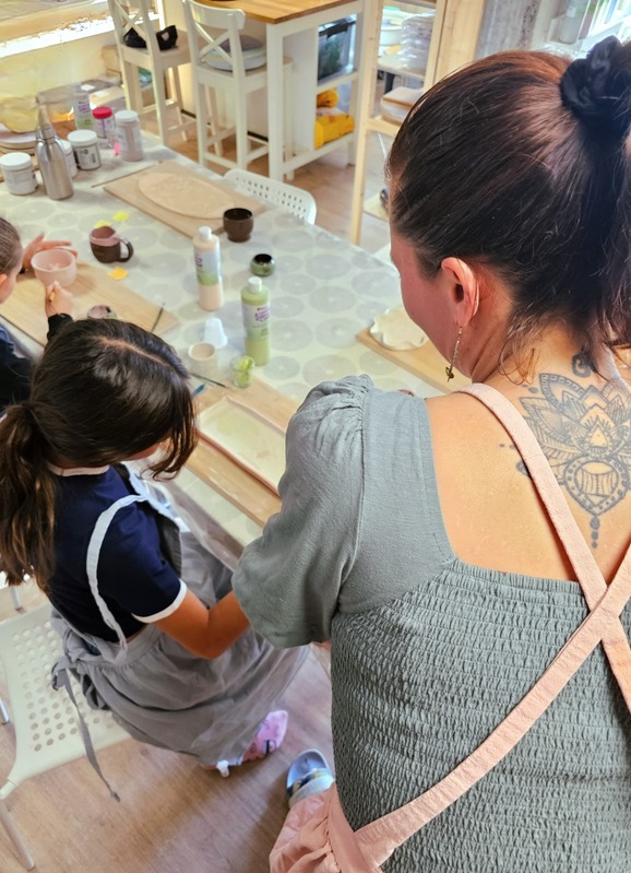 Nathalie accompagne un enfant pendant un atelier